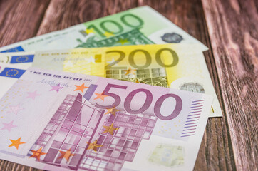 100, 200, 500 euro banknotes on a wooden background Financial concept.