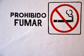 No smoking sign in Spanish with icon on white background
