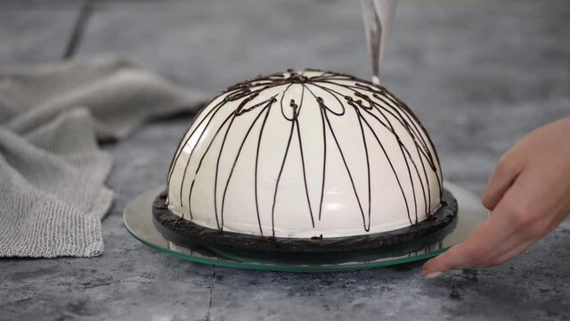 Pouring melted chocolate on top of a cake. Pancho cake with pineapple and sour cream topped with chocolate and nuts.