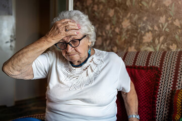 Portrait of an elderly woman in a state of worry at home
