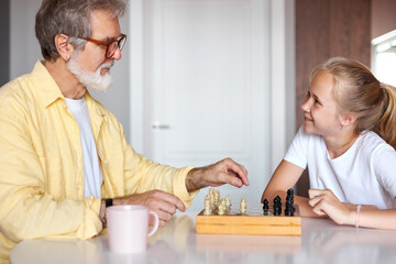 granddad transferring knowledge to young generation of family, mindful grandfather teaching granddaughter how to play chess