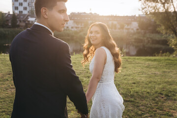 Fototapeta premium Just married beautiful caucasian couple happily runs to the lake