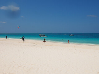 Fototapeta na wymiar Sunny beach day, white sand, blue Indian ocean in Zanzibar island, Tanzania. Copy space for text.