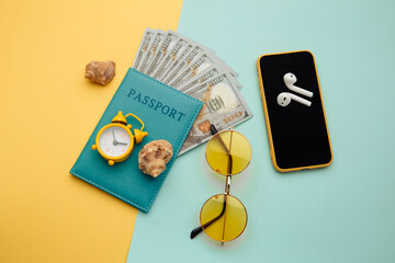 Summer vacation composition. Sunglasses, smartphone, shell and passport with money banknotes.