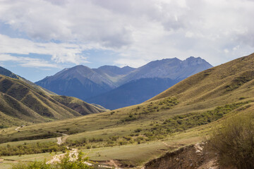 Fototapeta premium Beautiful Summer Landscape. Cloudy sky, mountains, hills and a mountain road. Sunny day. Central Asia, Kazakhstan.