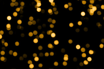 Blurry colored Christmas holiday lights on a black background.