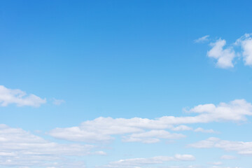 White cumulus clouds against the background against blue on a blue background.