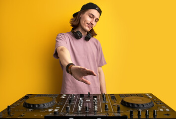 handsome young musician look at dj set or equipment in studio, think, holding hand above
