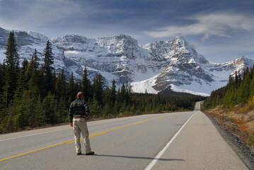 Traveler on Icefields Parkway looking at snow covered Waputik Range Mountains