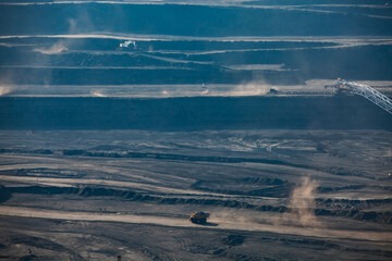 Open pit extraction of coal in quarry "Bogatyr", Ekibastuz, Kazakhstan. Quarry truck and excavator on the road.