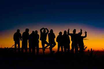 silhouettes of people together in a beautiful sunset at the mountain