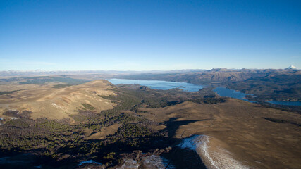 Volcano Batea Mahuida. Aerial view of the mountains, valley, forest and lake from the summit of the volcano.
