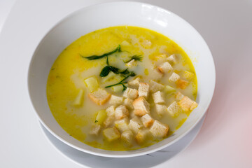 A white plate with cheese soup with rusks - obrazy, fototapety, plakaty