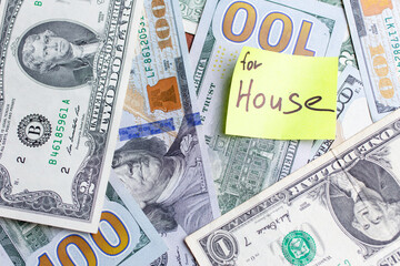 Yellow stick notes on an USD money background. Saving money for house concept