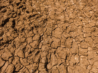 Dry black cotton soil in summer season. Broken soil, dry soil pattern texture.