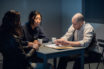 An experienced investigator and a female police officer interrogate the suspect.
