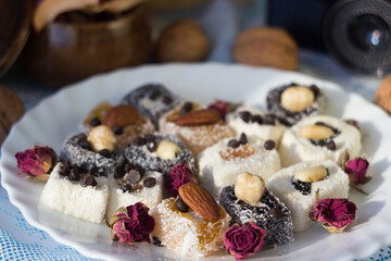 Assorted Turkish delight on a white plate, Turkish multicolored sweets with nuts. Goodies