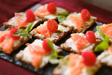 Croutons with Philadelphia cheese and salted salmon and sweet cherry. Catering dishes, snacks