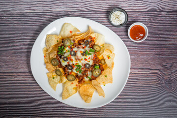 Mexican Famous Food Spicy Ground Beef Nachos. Heated crunchy tortilla chips with melted cheese and jalapeno served a snack food.