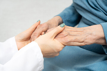 Young nurse hands holding an old hands of senior woman. Support for the elderly concept.