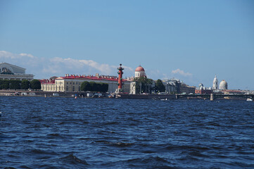 View from a boat to the coast in the city of St. Petersburg in Russia, you can see the bridge, rastral columns and old buildings on the embankment.