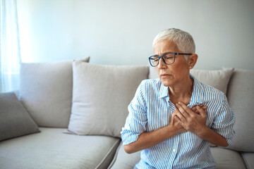 Woman having a pain in the heart area. Heart Attack. Painful Chest. Health Care, Medical Concept. High Resolution. Woman having heart attack at home