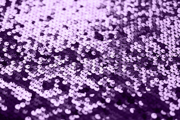 Sequin fabric texture. Shiny silver sparkling background. Clothing piece of glitter metallic for a glamorous party, celebration. Close-up. Toned image.