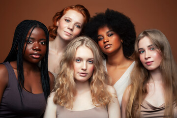 Obraz premium young pretty asian, caucasian, afro woman posing cheerful together on brown background, lifestyle diverse nationality people concept