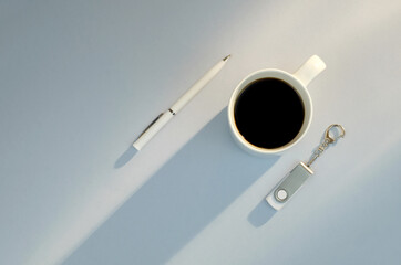 Flash drive, pen, cup of coffee on blue background with copy space, minimalism business style, growing up concept
