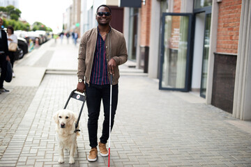 african american disabled man with helpful dog, dark skinned guy walking with friendly dog golden retriever