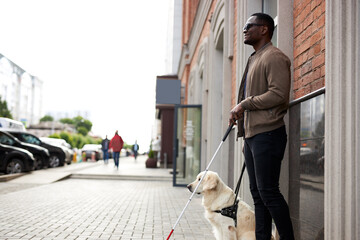 african american disabled man with helpful dog, dark skinned guy walking with friendly dog golden...