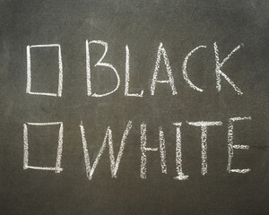 Fototapeta premium Questionnaire written in chalk on a blackboard with the words black or white