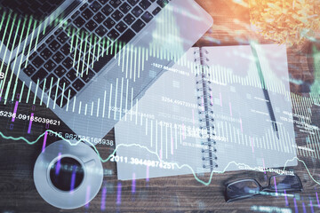 Financial market graph and top view computer on the desktop background. Double exposure. Investment concept.