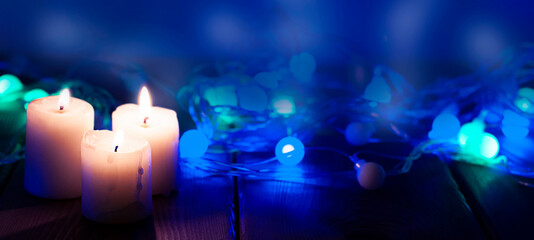 candles on the blue night background with garland