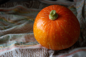 Small orange pumpkin on the napkin