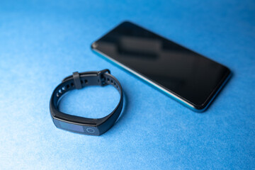 phone and fitness tracker on blue background