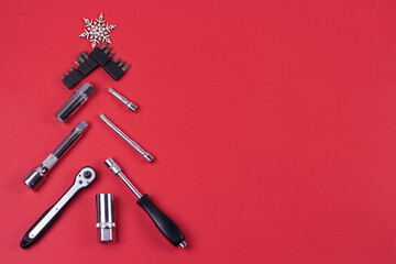 Creative christmas tree on red background, made of wrenches.Set of tools supplies for repair car on xmas backdrop. Industrial greeting card and christmas happy new year concept.