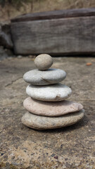 Fototapeta na wymiar Balanced tower made of oval stones on a concrete base