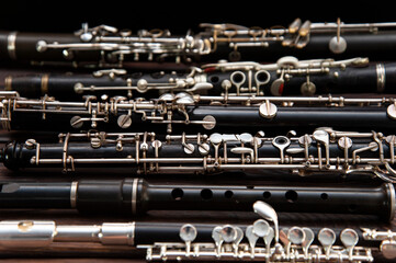 Many woodwind instruments lie on a wooden surface. View from above