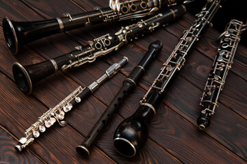 Woodwind instruments lie on a wooden surface. View from above - obrazy, fototapety, plakaty