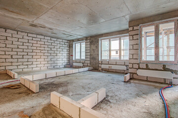 Unfinished construction empty room. Walls from lightweight aggregate concrete blocks with empty doorframes, unfinished interior, house under construction