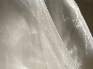 Organza in white and beige or champagne color close-up. Lightweight sheer tulle curtains under side...
