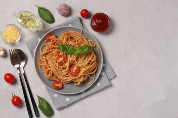 Spaghetti with tomato sauce and cherry tomatoes with basil on gray plate, Top view, Copy space