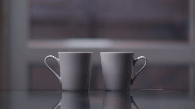 two mugs in a room with steam, mugs are waiting for their owners for a good cozy evening together