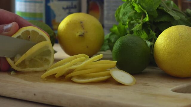 Cutting lemon into slices on a chopping bard