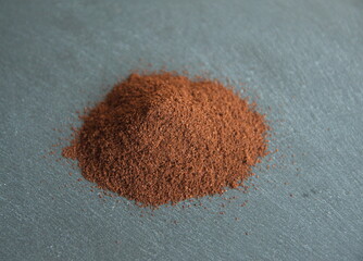 Coffee powder, roasted beans of Coffea arabica, on grey stone background