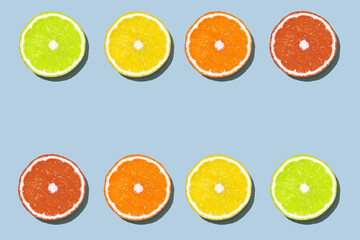 Citrus slices on blue background: grapefruit, orange, lemon, lime. Juicy fruits of different color - red grapefruit, orange orange, yellow lemon, lime green. Fruit juice or fruit cocktail concept.