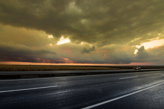 driving on the highway at sunset under the dark clouds