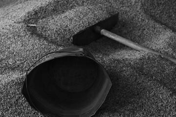 Grayscale shot of shovel and bucket for collecting grains