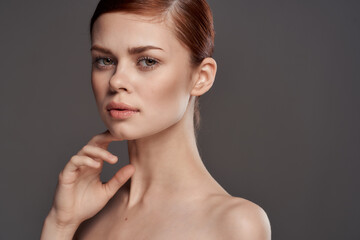 Fototapeta na wymiar Beautiful woman naked shoulders cosmetics clean skin charm gray background studio